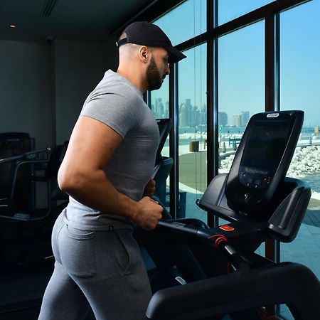 Mina Hotel And Residences By The Torch الدوحة المظهر الخارجي الصورة A man exercising on a treadmill