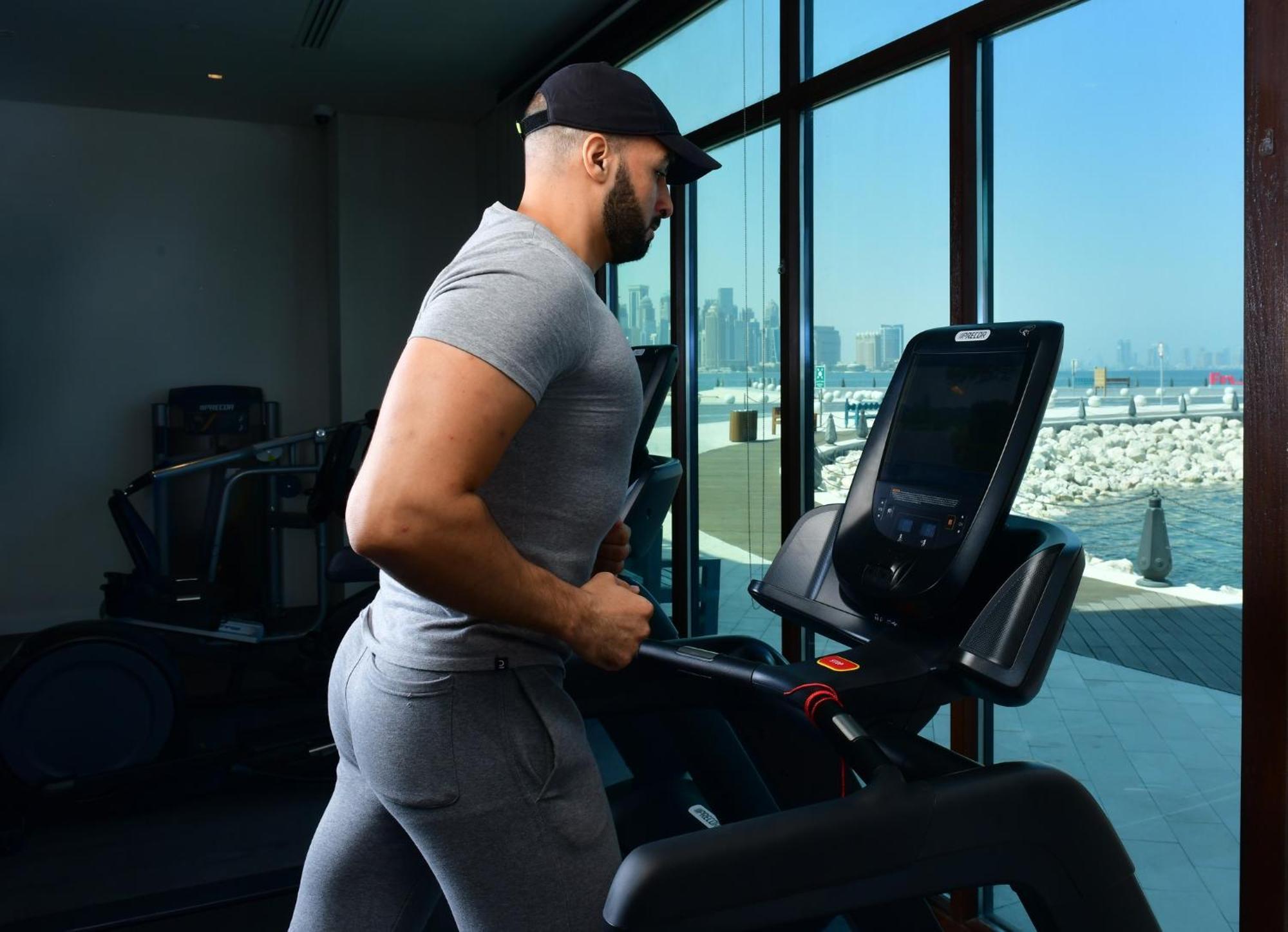 Mina Hotel And Residences By The Torch الدوحة المظهر الخارجي الصورة A man exercising on a treadmill